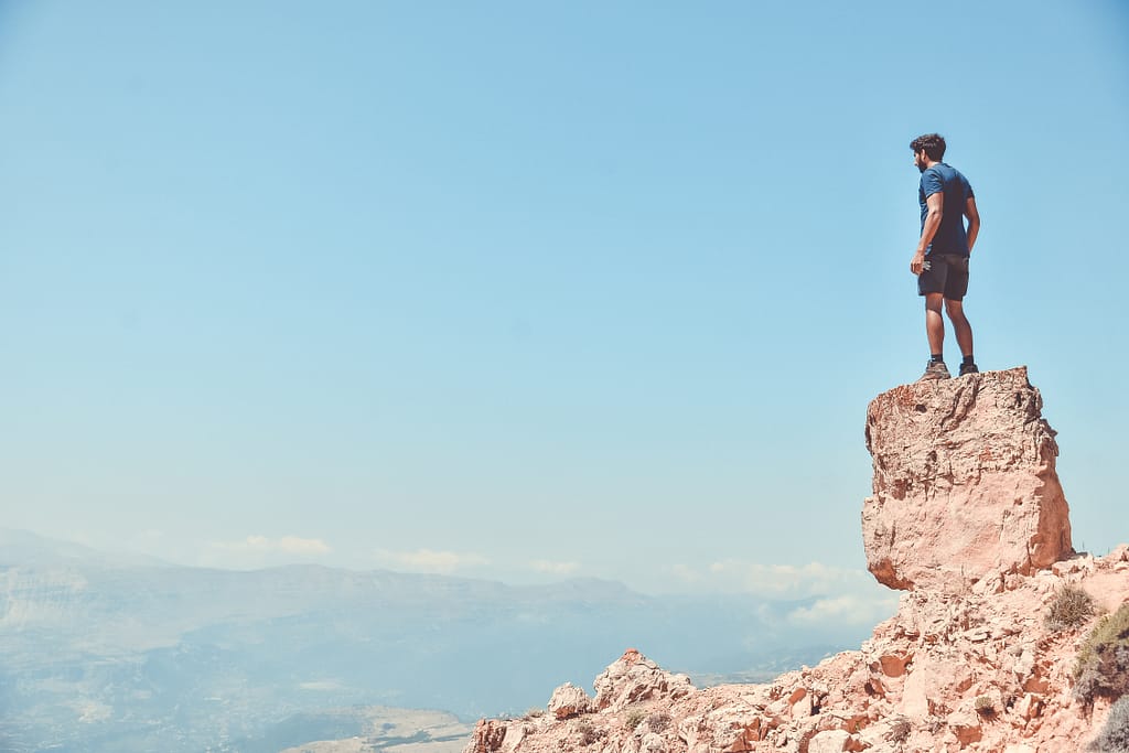 Man standing on a cliff looking off into the distance