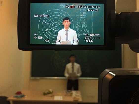 HOCMAI teacher recording a video lesson in front of a chalkboard