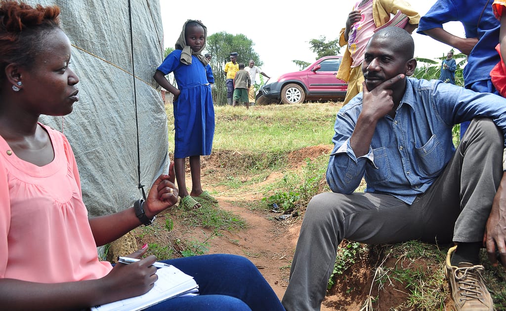 Olive Ashimwe, a business development associate at AEC, discusses potential business challenges with a coffee farmer client in Rwanda's eastern province. 