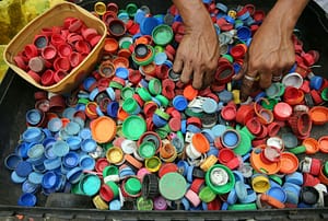 person sorting plastic bottle caps representing plastic recycling