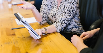 Intrapreneurship cover photo - woman in meeting showing tablet to seatmate