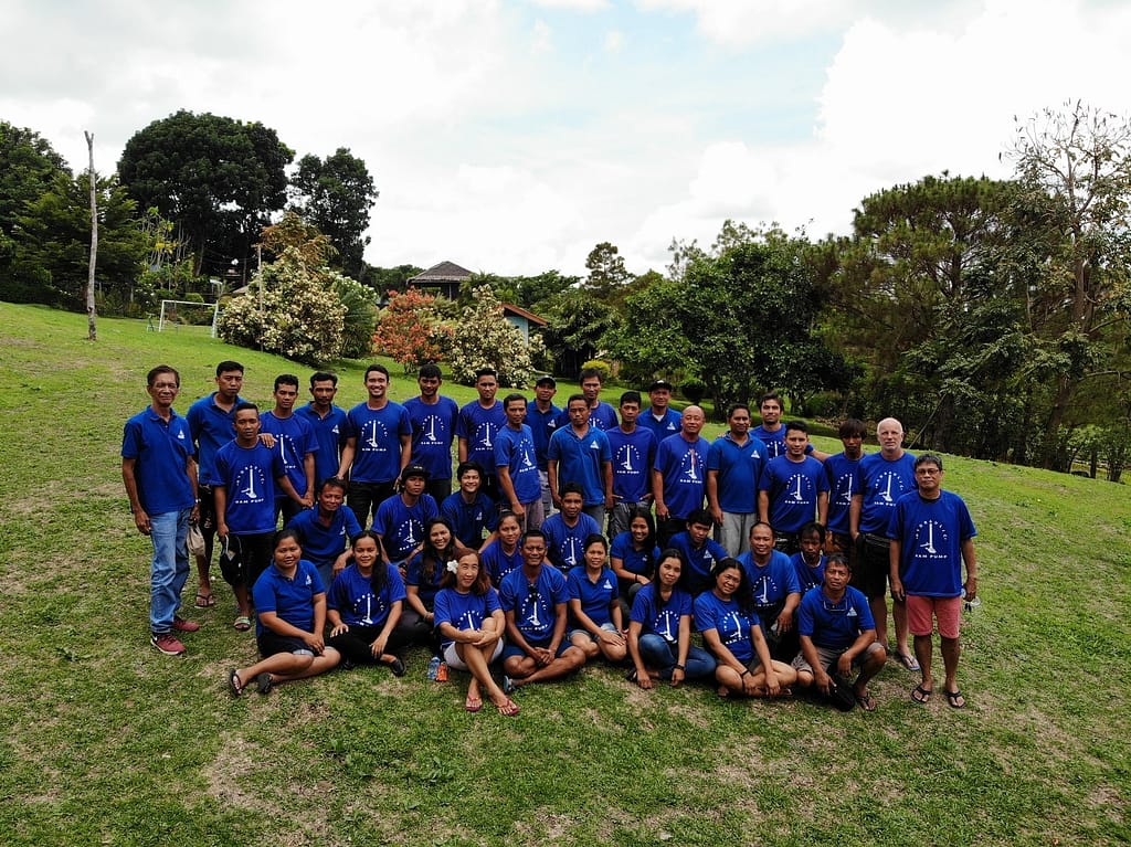 AIDFI team with volunteer, Stephen standing on a grassy hill