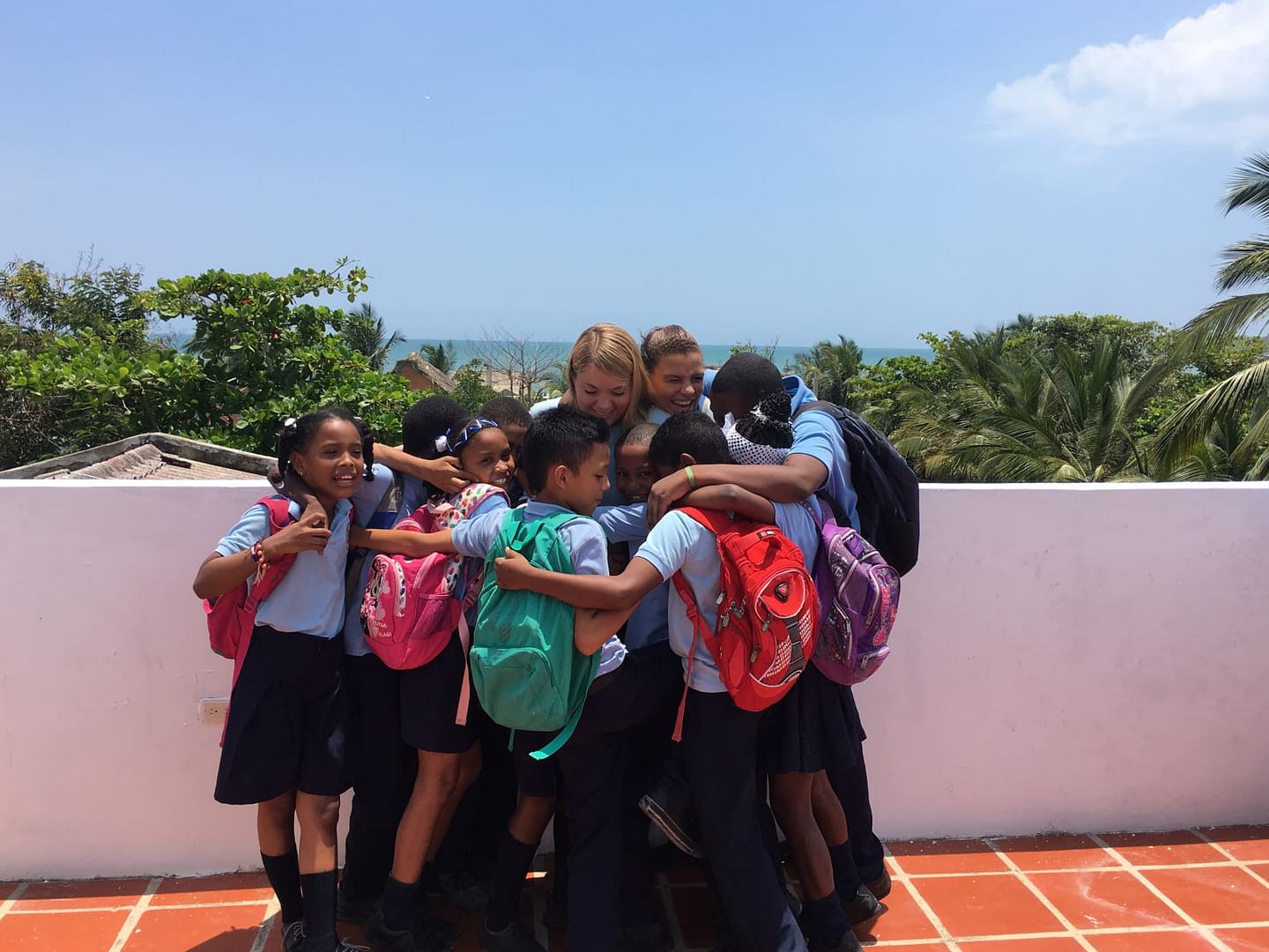 Emilia and group hug with kids 5th grade