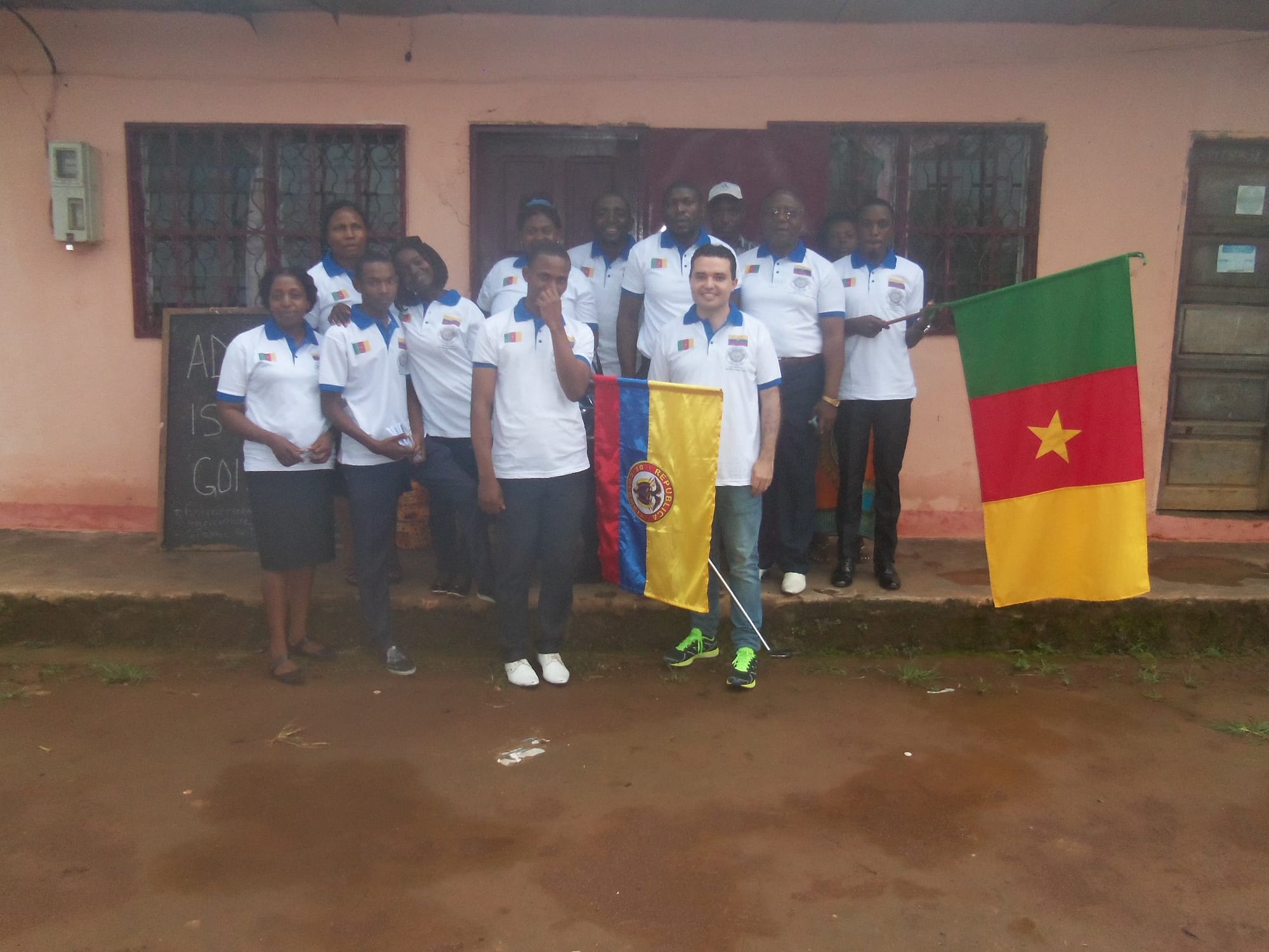 Eduardo and students outside the Tobby Vision school with the flag of Cameroon. 