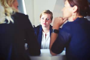 Woman in business suit sitting across the table from other businesswoman during an interview