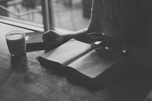 person reading book in coffee shop