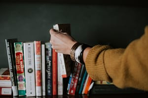 hand taking book from bookshelf