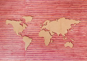 world map cutout on pink background