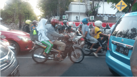The city traffic jam: cars surrounded by crowded motorcycles. 