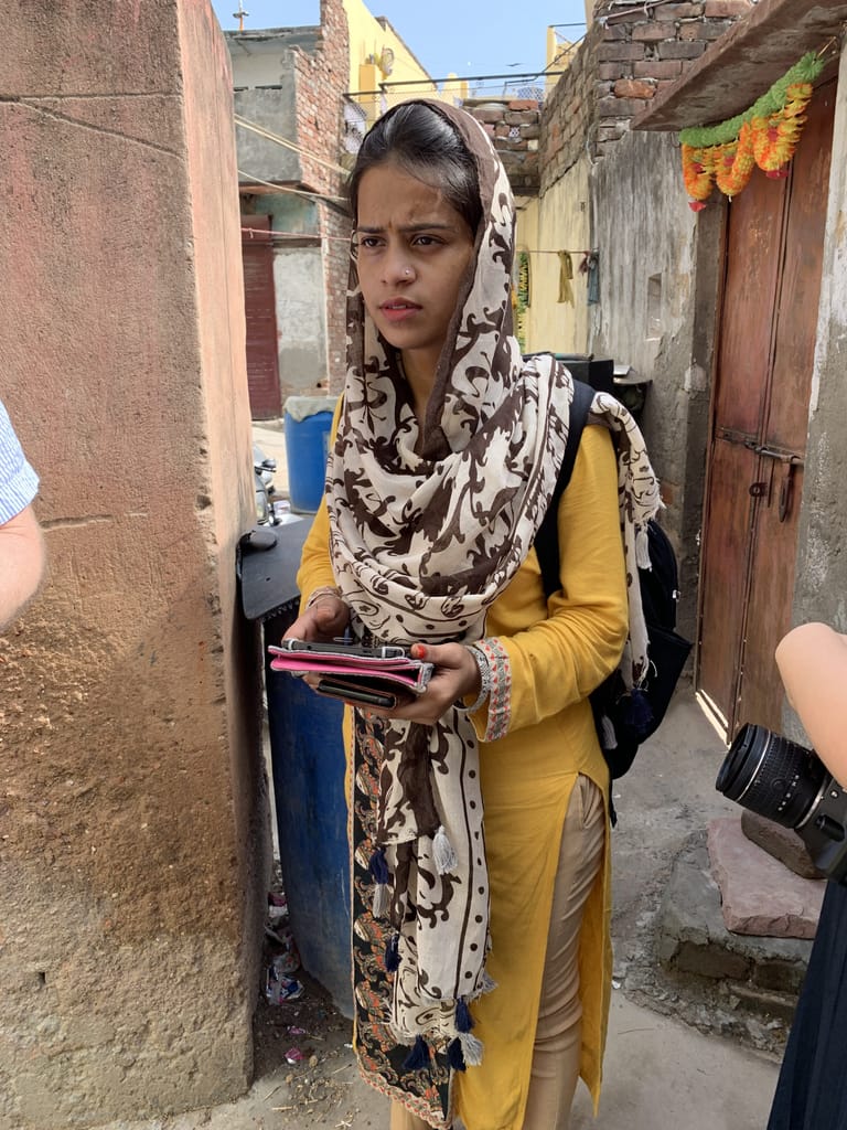 Operation ASHA team member holding a tablet in Tekhand Village and giving feedback on the mobile app